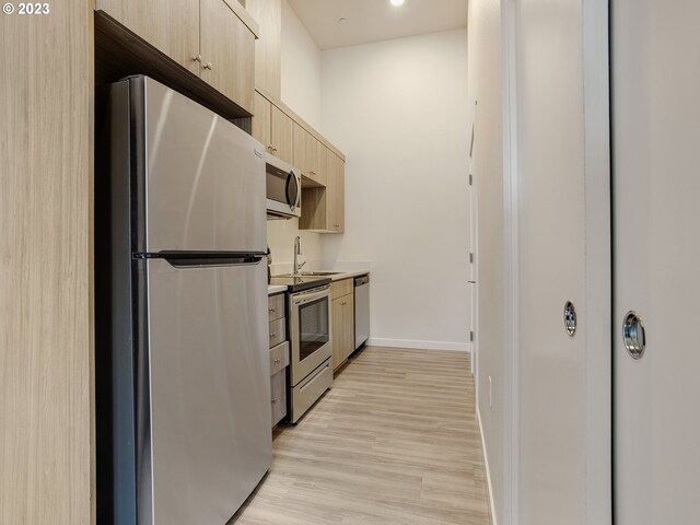 4738 SE Belmont St, Portland, OR 97215 - kitchen featuring light wood-type flooring, light brown cabinetry, and stainless steel appliances