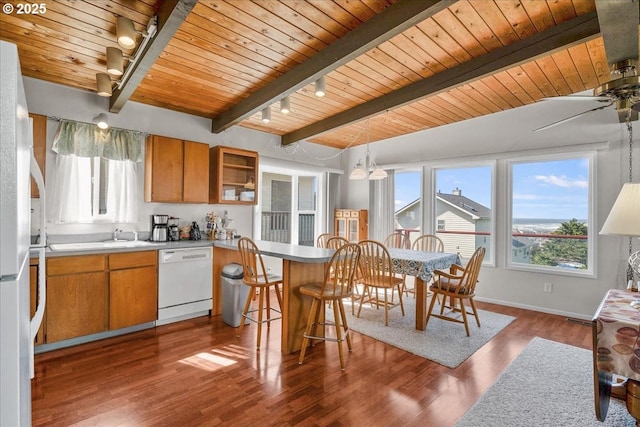 kitchen featuring white appliances, wooden ceiling, healthy amount of natural light, track lighting, and beamed ceiling