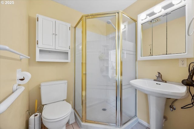 full bathroom with a stall shower, toilet, and a sink