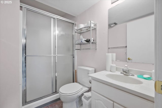 bathroom with a shower stall, vanity, and toilet