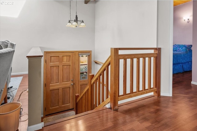entryway featuring wood finished floors, baseboards, and a chandelier