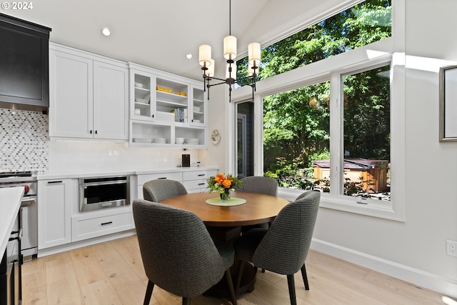 dining room with a notable chandelier, recessed lighting, baseboards, and light wood-style floors