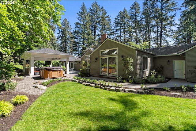 view of front of property with a chimney, a hot tub, a gazebo, a front lawn, and a patio area