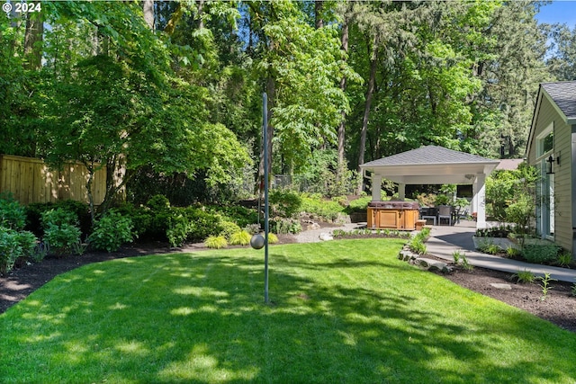 view of yard featuring a gazebo, a hot tub, a patio, and fence