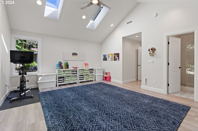 exercise area with a skylight, wood finished floors, and visible vents