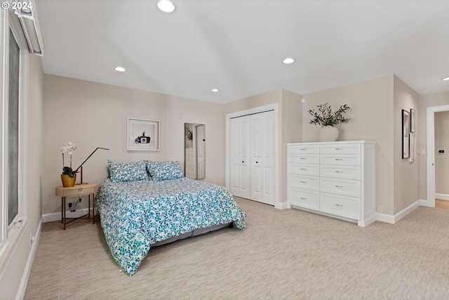 bedroom featuring a closet, recessed lighting, light colored carpet, and baseboards