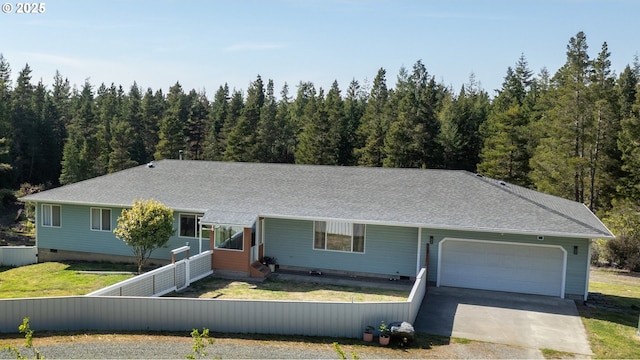 53310 Morrison Rd, Bandon, OR 97411 - view of front of house featuring an attached garage, driveway, roof with shingles, and a forest view