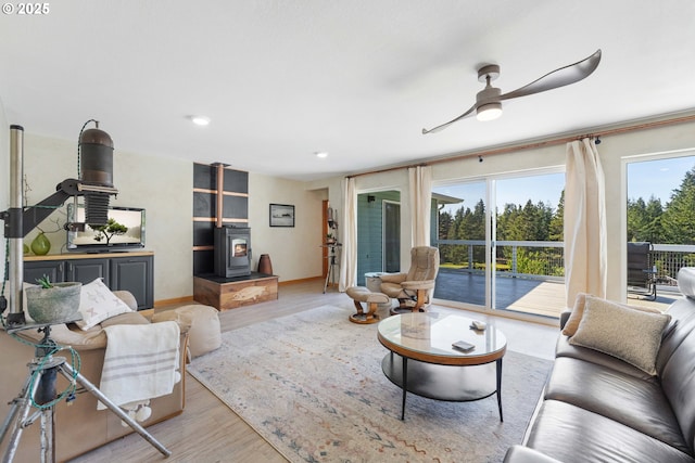 53310 Morrison Rd, Bandon, OR 97411 - living area with light wood-type flooring, a wood stove, a ceiling fan, and recessed lighting