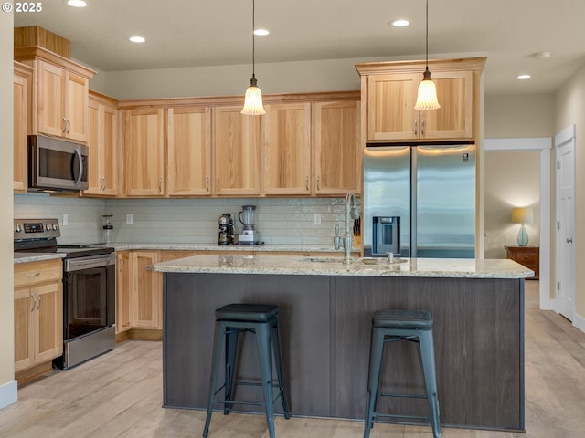 293 W Kershul Cir, Gearhart, OR 97138 - kitchen featuring stainless steel appliances, light brown cabinetry, light wood-style flooring, decorative backsplash, and recessed lighting