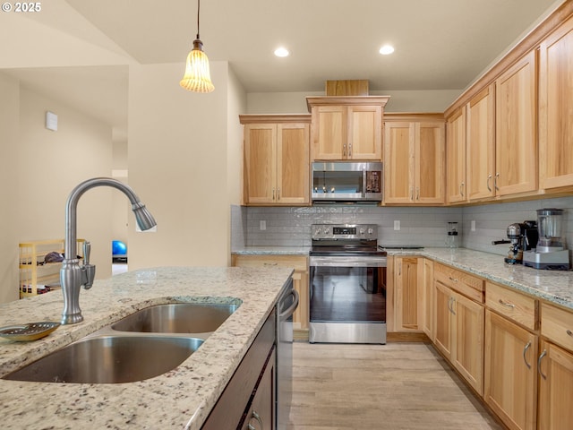 293 W Kershul Cir, Gearhart, OR 97138 - kitchen featuring appliances with stainless steel finishes, light brown cabinetry, light wood finished floors, backsplash, and hanging light fixtures