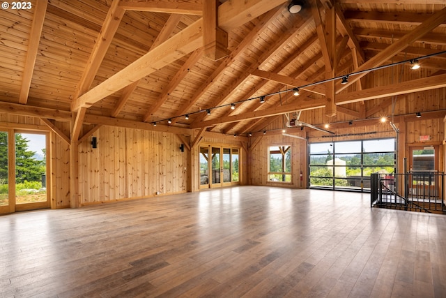 interior space with beam ceiling, light hardwood / wood-style floors, wood ceiling, and wood walls