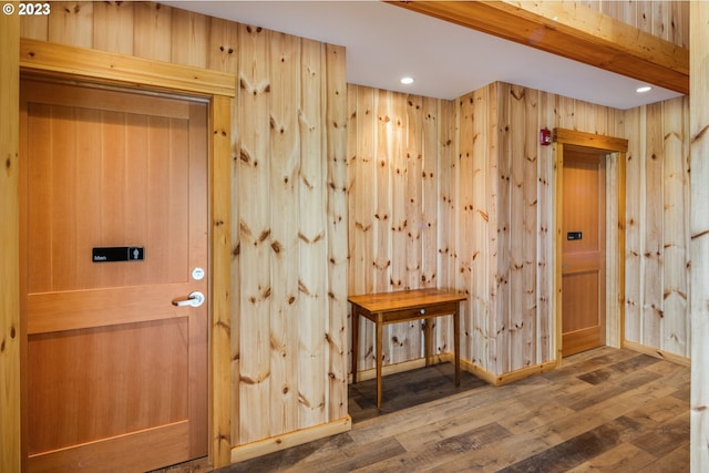 entryway with dark hardwood / wood-style flooring and wooden walls