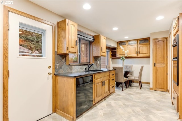 kitchen featuring backsplash, dishwasher, and sink