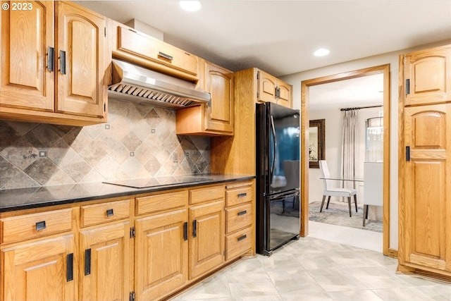 kitchen featuring backsplash, extractor fan, and black appliances