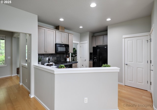 728 NE 72nd Ave, Hillsboro, OR 97124 - kitchen with black appliances, light wood-type flooring, decorative backsplash, recessed lighting, and a peninsula