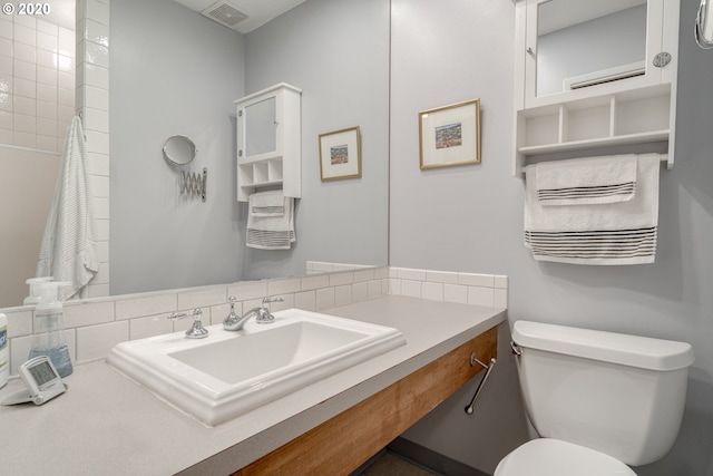 bathroom with vanity, tasteful backsplash, toilet, and tile walls