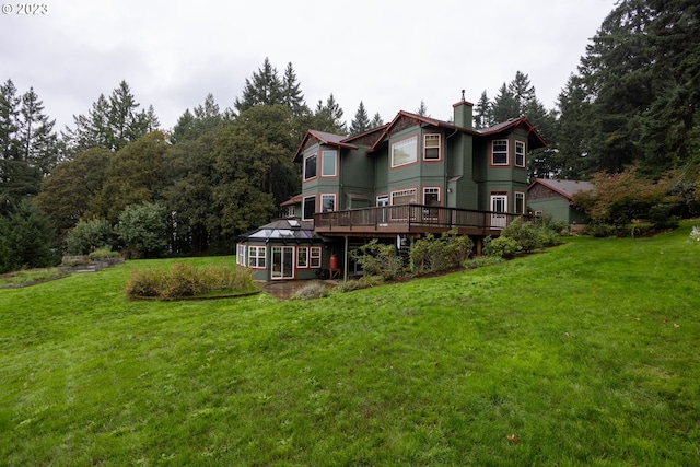 back of property with a wooden deck and a yard