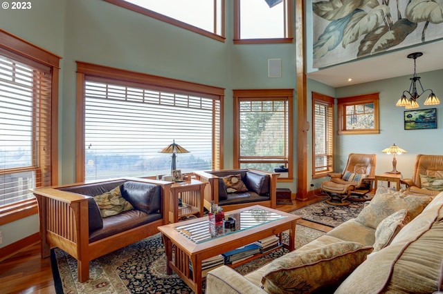 living room featuring an inviting chandelier, a wealth of natural light, and hardwood / wood-style floors