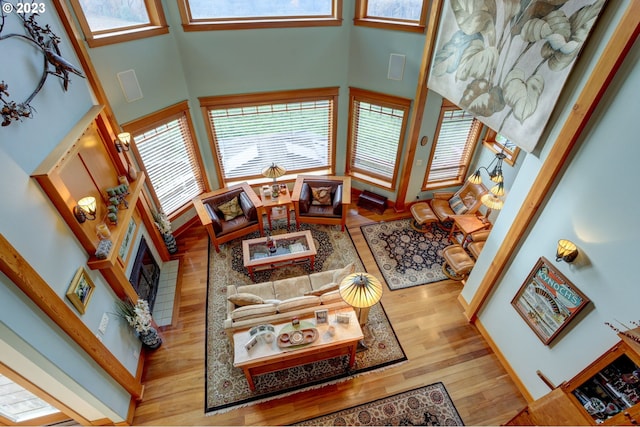 living room with light hardwood / wood-style floors and a towering ceiling