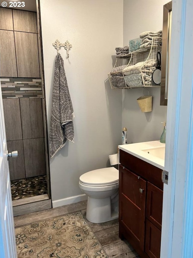 206 NE Front St, Prairie City, OR 97869 - bathroom featuring vanity, hardwood / wood-style floors, toilet, and walk in shower