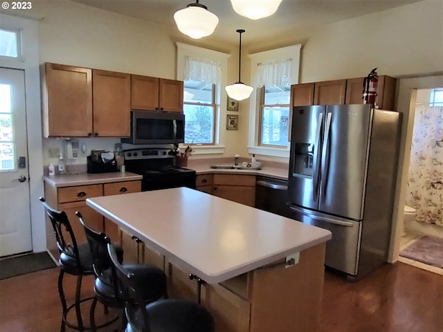 206 NE Front St, Prairie City, OR 97869 - kitchen with hanging light fixtures, a breakfast bar, appliances with stainless steel finishes, and sink