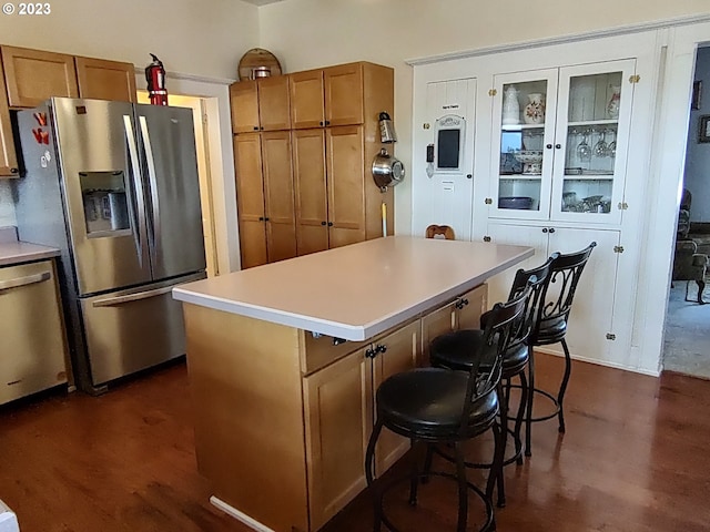 206 NE Front St, Prairie City, OR 97869 - kitchen featuring dark hardwood / wood-style floors, stainless steel appliances, a breakfast bar, and a center island