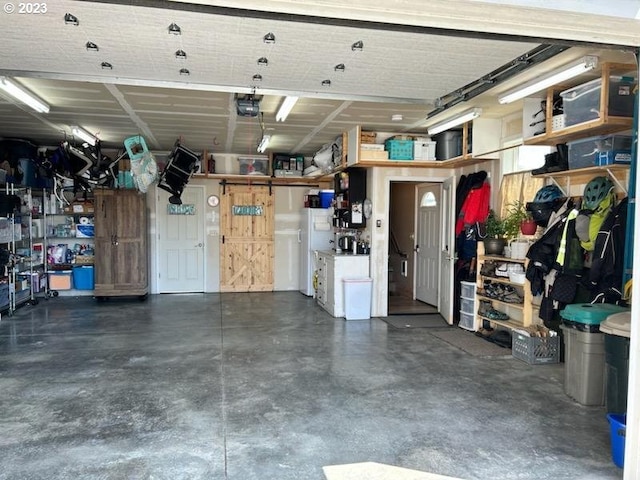 206 NE Front St, Prairie City, OR 97869 - garage featuring white refrigerator and a garage door opener