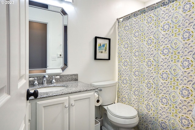bathroom with vanity, a shower with shower curtain, and toilet