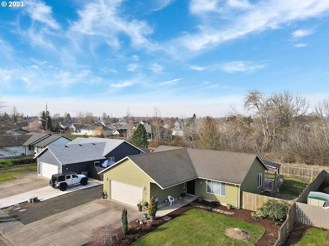 single story home with concrete driveway, fence, a garage, and a residential view