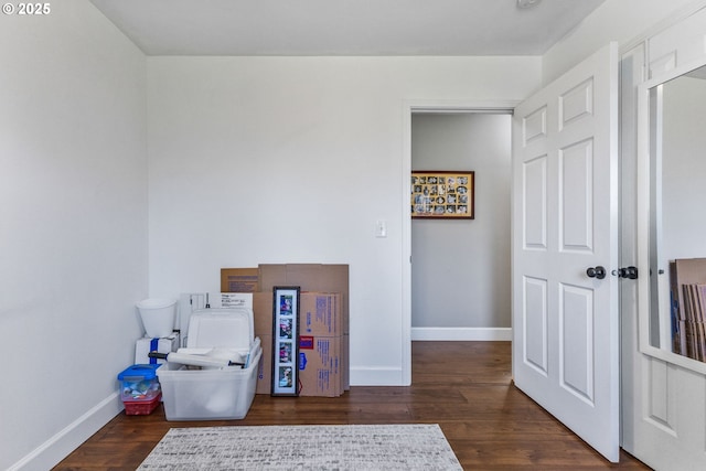 miscellaneous room with baseboards and dark wood finished floors