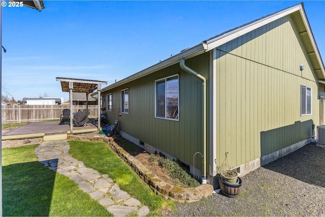 view of side of home featuring a deck and fence