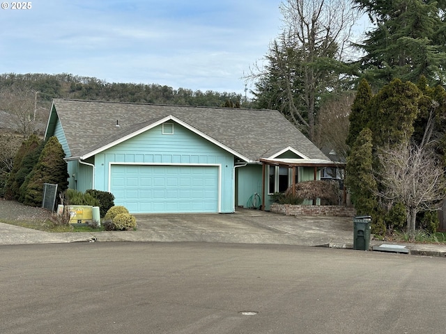 ranch-style home featuring a garage, driveway, and roof with shingles