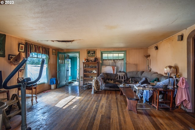 living room with a textured ceiling and dark wood-type flooring