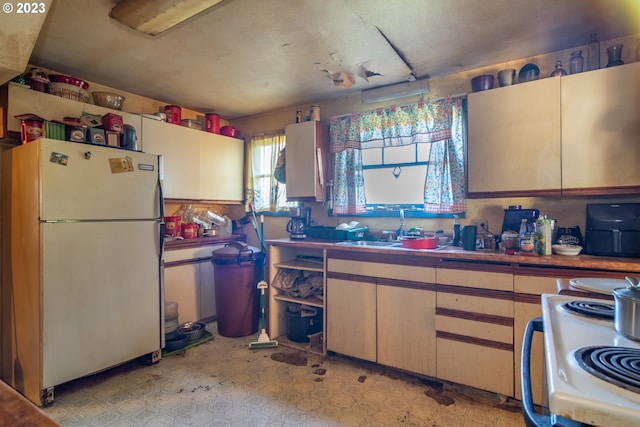 kitchen featuring light tile flooring, white fridge, range, and sink