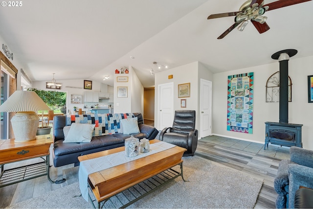 38225 Hiagua Ln N, Nehalem, OR 97131 - living area with lofted ceiling, wood finished floors, a wood stove, a ceiling fan, and a chandelier