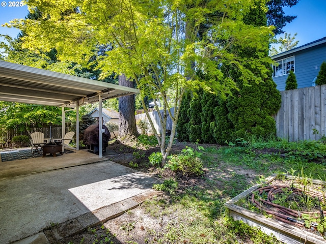 view of yard featuring a fenced backyard, an outdoor fire pit, and a patio area