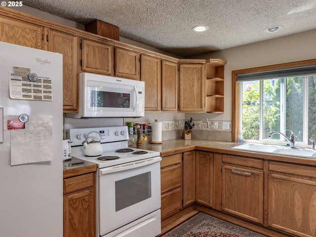 kitchen featuring a sink, open shelves, a textured ceiling, white appliances, and light countertops
