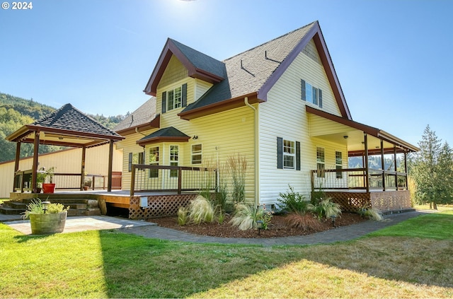 back of house with a porch and a yard