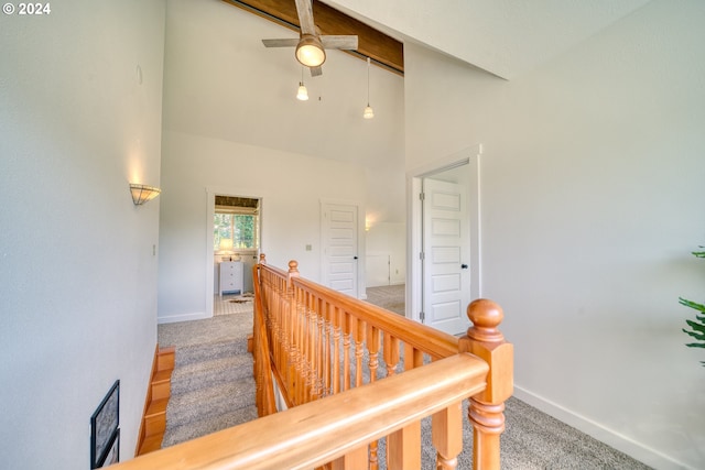 corridor featuring carpet floors and high vaulted ceiling