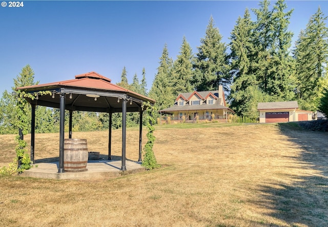 view of yard featuring a gazebo, a garage, and an outbuilding