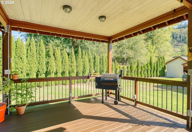 wooden terrace with a yard and grilling area