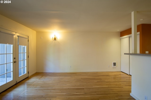 spare room with french doors and light hardwood / wood-style floors