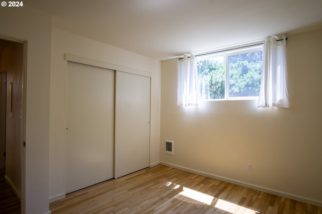 unfurnished bedroom featuring light hardwood / wood-style floors and a closet