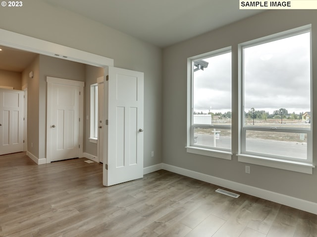 unfurnished room with light wood-type flooring