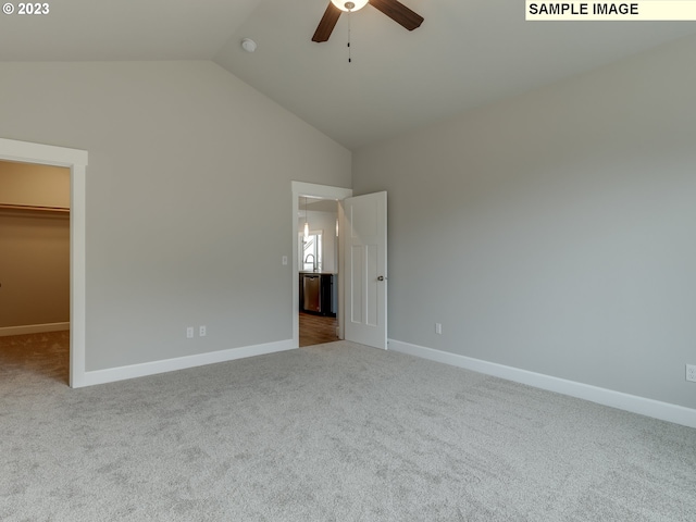 unfurnished bedroom featuring a walk in closet, carpet floors, high vaulted ceiling, a closet, and ceiling fan