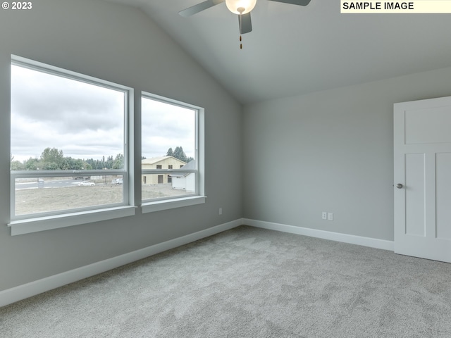 carpeted spare room with a healthy amount of sunlight, lofted ceiling, and ceiling fan