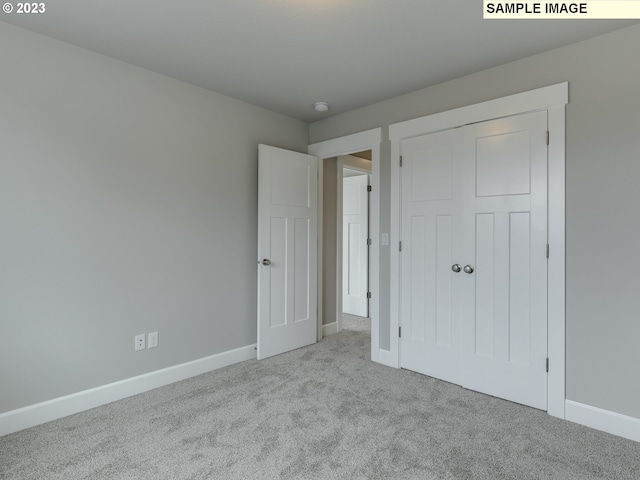 unfurnished bedroom with a closet and light carpet