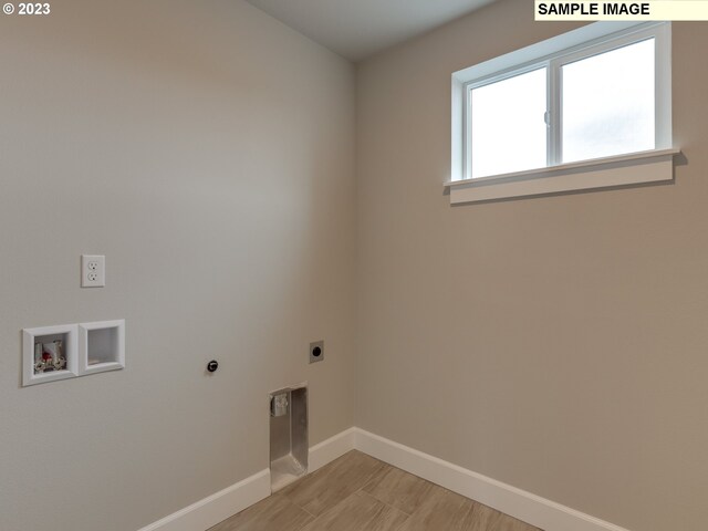 clothes washing area featuring light hardwood / wood-style flooring, washer hookup, and hookup for an electric dryer