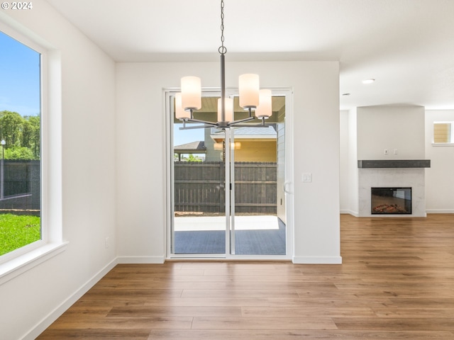 unfurnished dining area featuring hardwood / wood-style flooring and a notable chandelier