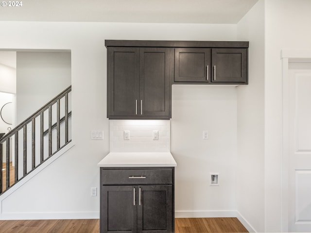 kitchen with light hardwood / wood-style floors, decorative backsplash, and dark brown cabinetry